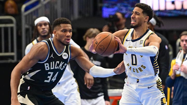 Nov 22, 2024; Milwaukee, Wisconsin, USA; Indiana Pacers guard Tyrese Haliburton (0) looks to pass the ball away from Milwaukee Bucks forward Giannis Antetokounmpo (34) in the third quarter at Fiserv Forum. Mandatory Credit: Benny Sieu-Imagn Images