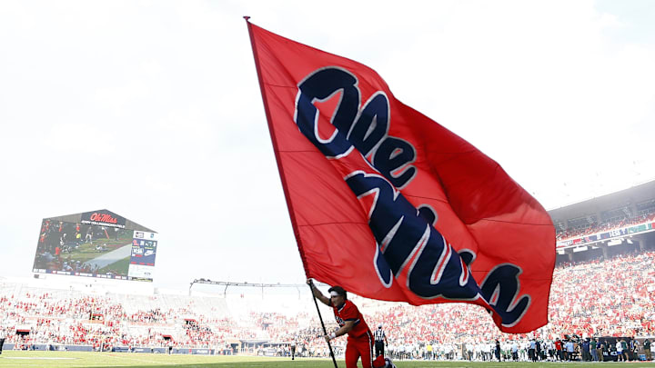 Sep 20, 2025; Oxford, Mississippi, USA; Mississippi Rebels cheerleader run an Ole Miss flag through the end zone after a touchdown during the fourth quarter against the Tulane Green Wave at Vaught-Hemingway Stadium. Mandatory Credit: Petre Thomas-Imagn Images