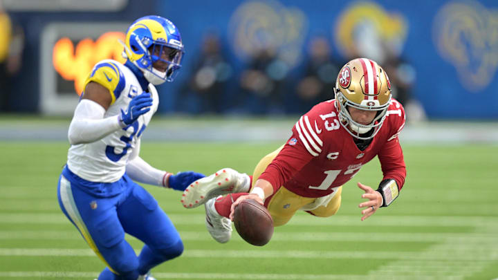 Sep 22, 2024; Inglewood, California, USA;  San Francisco 49ers quarterback Brock Purdy (13) gets past Los Angeles Rams linebacker Jacob Hummel (35) as he reaches mid-air for a first down before he is forced out of bounds in the second half at SoFi Stadium. Mandatory Credit: Jayne Kamin-Oncea-Imagn Images