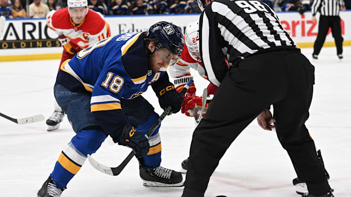 Jan 16, 2025; St. Louis, Missouri, USA; St. Louis Blues center Robert Thomas (18) faces off against Calgary Flames center Blake Coleman (20) in the third period at Enterprise Center. Mandatory Credit: Joe Puetz-Imagn Images