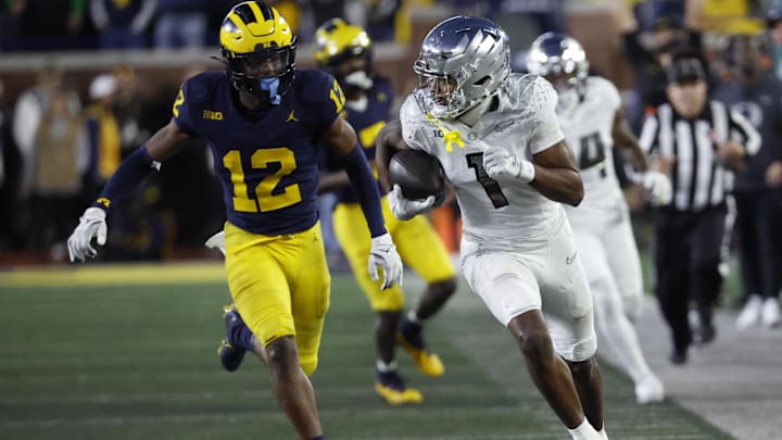 Nov 2, 2024; Ann Arbor, Michigan, USA;  Oregon Ducks wide receiver Traeshon Holden (1) runs the ball chased by Michigan Wolverines defensive back Aamir Hall (12) in the second half at Michigan Stadium. Mandatory Credit: Rick Osentoski-Imagn Images