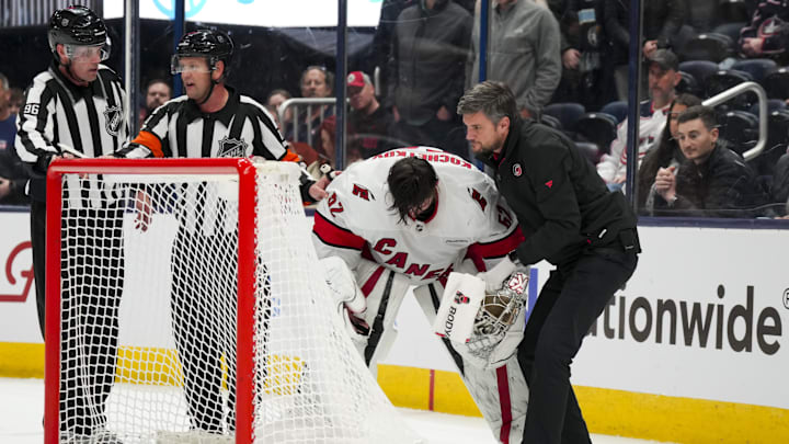 Nov 23, 2024; Columbus, Ohio, USA;  Carolina Hurricanes goaltender Pyotr Kochetkov (52) is tended to by the Hurricanes’ head athletic trainer Doug Bennett during a stop in play in the game against the Columbus Blue Jackets in the overtime period at Nationwide Arena. Mandatory Credit: Aaron Doster-Imagn Images