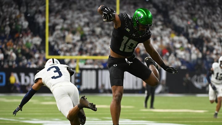 Dec 7, 2024; Indianapolis, IN, USA; Oregon Ducks tight end Kenyon Sadiq (18) hurdles Penn State Nittany Lions cornerback Jalen Kimber (3) for a touchdown during the first quarter in the 2024 Big Ten Championship game at Lucas Oil Stadium. Mandatory Credit: Robert Goddin-Imagn Images
