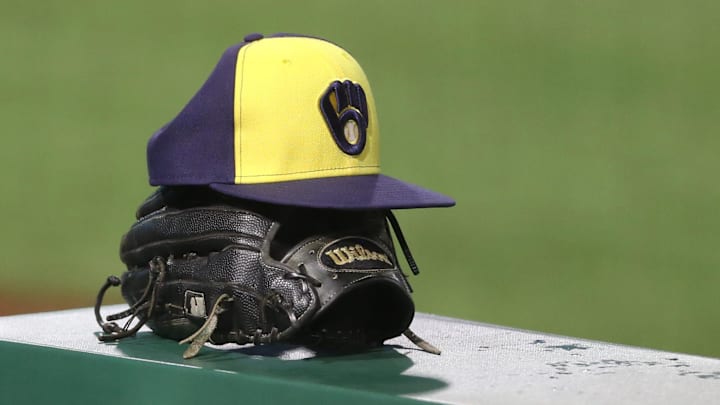 Jul 27, 2020; Pittsburgh, Pennsylvania, USA;  A Milwaukee Brewers hat and glove on the dugout rail against the Pittsburgh Pirates during the tenth inning at PNC Park.Milwaukee won 6-5 in eleven innings.  Mandatory Credit: Charles LeClaire-Imagn Images