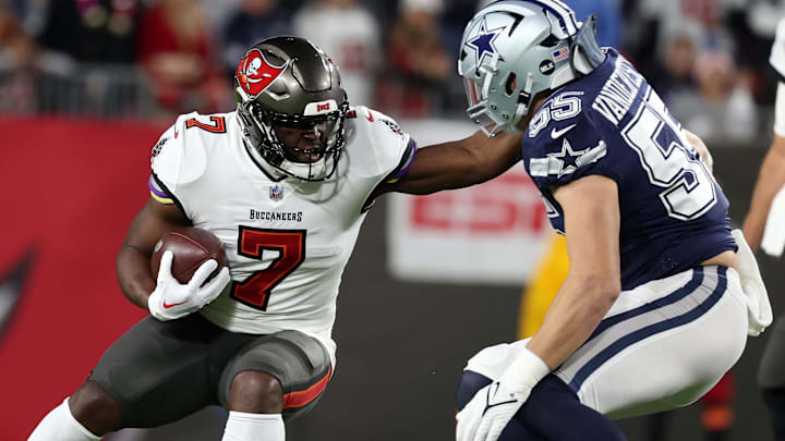 Jan 16, 2023; Tampa, Florida, USA; Tampa Bay Buccaneers running back Leonard Fournette (7) rushes the ball against the Dallas Cowboys linebacker Leighton Vander Esch (55) in the first half during the wild card game at Raymond James Stadium. Mandatory Credit: Kim Klement-Imagn Images
