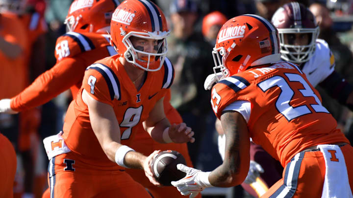 Nov 2, 2024; Champaign, Illinois, USA;  Illinois Fighting Illini quarterback Luke Altmyer (9) hands the ball to running back Jordan Anderson (23) during the first half at Memorial Stadium. Mandatory Credit: Ron Johnson-Imagn Images