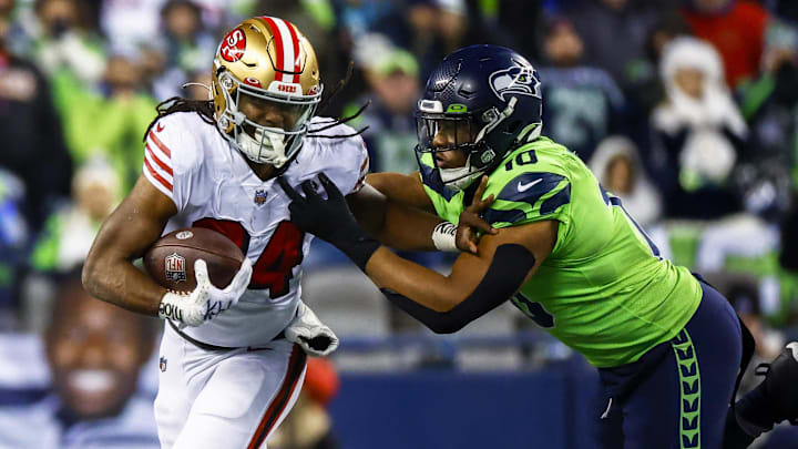 Dec 15, 2022; Seattle, Washington, USA; San Francisco 49ers running back Jordan Mason (24) breaks a tackle attempt by Seattle Seahawks linebacker Uchenna Nwosu (10) during the fourth quarter at Lumen Field. Mandatory Credit: Joe Nicholson-Imagn Images