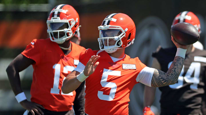 Cleveland Browns quarterback Dillon Gabriel (5) throws as quarterback Shedeur Sanders (12) looks on during rookie minicamp May 9, 2025, in Berea.