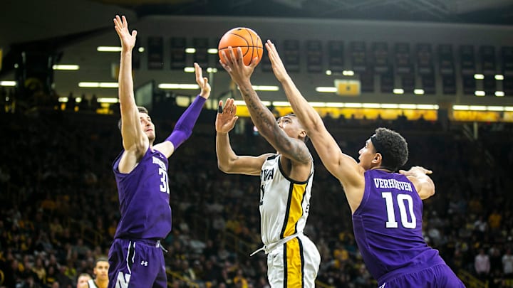 Iowa guard Tony Perkins, center, drives to the basket as Northwestern forwards Robbie Beran, left, and Tydus Verhoeven defend during an NCAA Big Ten Conference men's basketball game, Tuesday, Jan. 31, 2023, at Carver-Hawkeye Arena in Iowa City, Iowa. Iowa guard Tony Perkins, center, drives to the basket as Northwestern forwards Robbie Beran, left, and Tydus Verhoeven defend during an NCAA Big Ten Conference men's basketball game, Tuesday, Jan. 31, 2023, at Carver-Hawkeye Arena in Iowa City, Iowa.