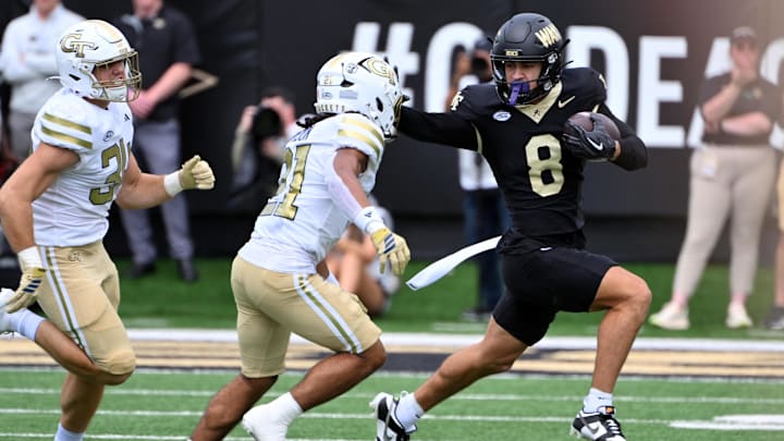Sep 27, 2025; Winston-Salem, North Carolina, USA;  Wake Forest Demon Deacons wide receiver Carlos Hernandez (8) runs the ball against Georgia Tech Yellow Jackets defensive back Elgin Sessions (21) during the first quarter at Allegacy Federal Credit Union Stadium. Mandatory Credit: Zachary Taft-Imagn Images
