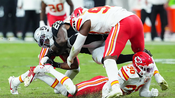 Oct 27, 2024; Paradise, Nevada, USA; Las Vegas Raiders running back Alexander Mattison (22) is tackled by Kansas City Chiefs cornerback Christian Roland-Wallace (30) and Kansas City Chiefs defensive tackle Tershawn Wharton (98) during the fourth quarter at Allegiant Stadium. Mandatory Credit: Stephen R. Sylvanie-Imagn Images