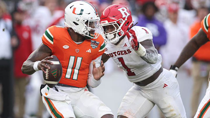 Dec 28, 2023; Bronx, NY, USA; Miami Hurricanes quarterback Jacurri Brown (11) is sacked by Rutgers Scarlet Knights linebacker Mohamed Toure (1) during the first half of the 2023 Pinstripe Bowl at Yankee Stadium. Mandatory Credit: Vincent Carchietta-Imagn Images