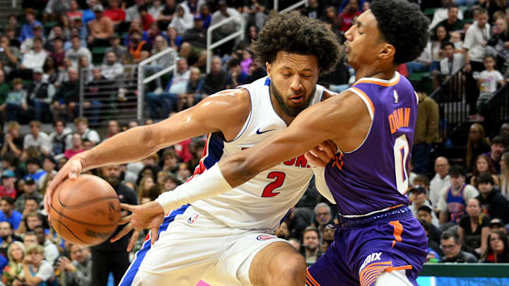 Oct 8, 2024; East Lansing, Michigan, USA;  Detroit Pistons guard Cade Cunningham (2) keeps the ball away from Phoenix Suns forward Ryan Dunn (0) at Jack Breslin Student Events Center. Mandatory Credit: Dale Young-Imagn Images
