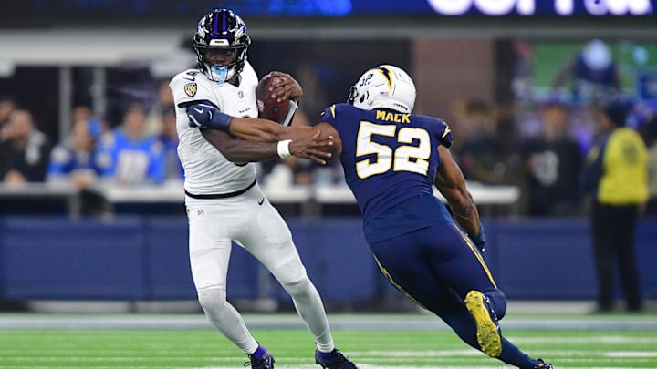 Nov 25, 2024; Inglewood, California, USA; Baltimore Ravens quarterback Lamar Jackson (8) runs the ball against Los Angeles Chargers linebacker Khalil Mack (52) during the second half at SoFi Stadium. Mandatory Credit: Gary A. Vasquez-Imagn Images