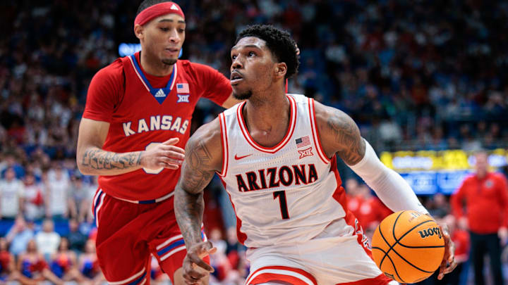 Arizona Wildcats guard Caleb Love (1) drives to the basket around Kansas Jayhawks guard Dajuan Harris Jr. (3) during the first half at Allen Fieldhouse. Arizona Wildcats guard Caleb Love (1) drives to the basket around Kansas Jayhawks guard Dajuan Harris Jr. (3) during the first half at Allen Fieldhouse.