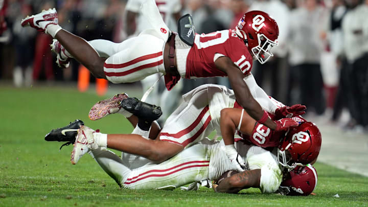 Oklahoma Sooners linebacker Kip Lewis (10) and defensive lineman Trace Ford (30) tackle Alabama Crimson Tide quarterback Jalen Milroe (4) during a college football game between the University of Oklahoma Sooners (OU) and the Alabama Crimson Tide at Gaylord Family - Oklahoma Memorial Stadium in Norman, Okla., Saturday, Nov. 23, 2024. Oklahoma won 24-3.