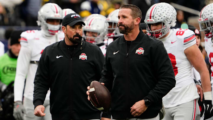 Ohio State Buckeyes offensive coordinator Brian Hartline and head coach Ryan Day leads warm ups during the NCAA football game against the Michigan Wolverines at Michigan Stadium in Ann Arbor, Mich. on Nov. 29, 2025. Ohio State won 27-9.