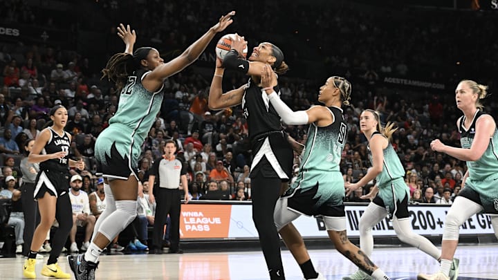 Aug 13, 2025; Las Vegas, Nevada, USA; Las Vegas Aces center A'ja Wilson (22) shoots against New York Liberty forward Kennedy Burke (22) and guard Natasha Cloud (9) during the second quarter of their game at Michelob Ultra Arena. Mandatory Credit: Candice Ward-Imagn Images