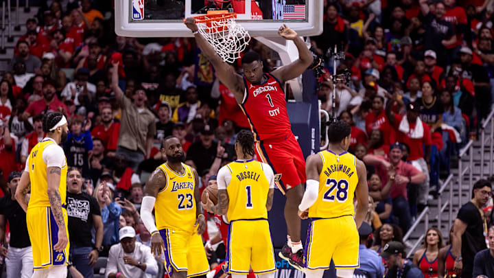 Apr 16, 2024; New Orleans, Louisiana, USA; New Orleans Pelicans forward Zion Williamson (1) dunks the ball against Los Angeles Lakers forward LeBron James (23) and guard D'Angelo Russell (1) during the second half of a play-in game of the 2024 NBA playoffs at Smoothie King Center. 