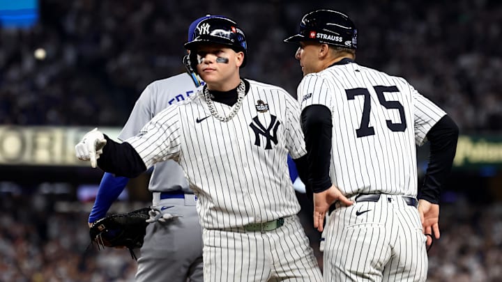 New York Yankees outfielder Alex Verdugo (24) celebrates with first base coach Travis Chapman (75) after hitting a RBI single during the second inning against the Los Angeles Dodgers in game five of the 2024 MLB World Series at Yankee Stadium. 