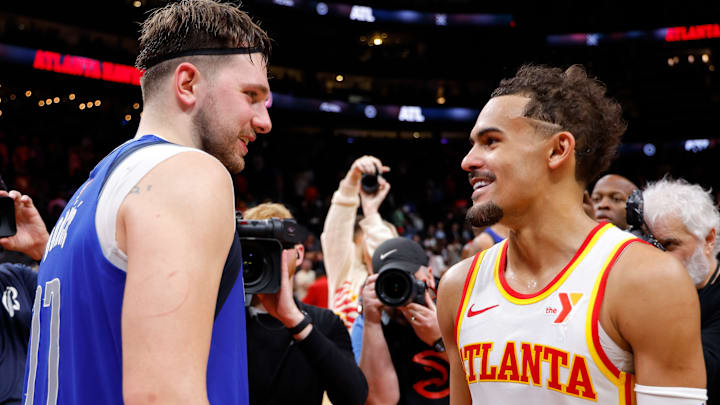 Former Dallas Mavericks star Luka Doncic #77 speaks with Trae Young #11 of the Atlanta Hawks.