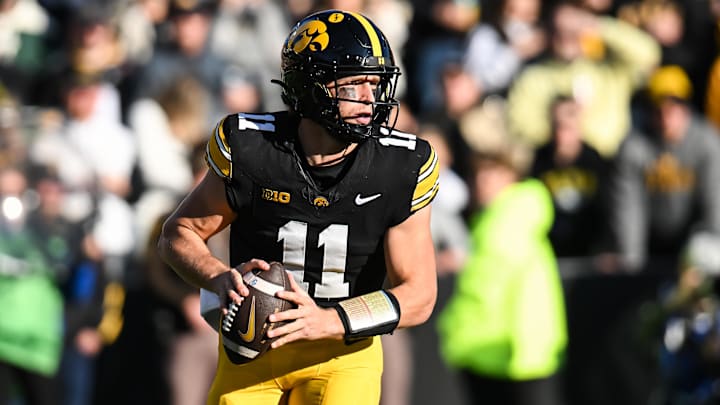 Nov 22, 2025; Iowa City, Iowa, USA; Iowa Hawkeyes quarterback Mark Gronowski (11) rolls out to throws a pass against the Michigan State Spartans during the first quarter at Kinnick Stadium. Mandatory Credit: Jeffrey Becker-Imagn Images