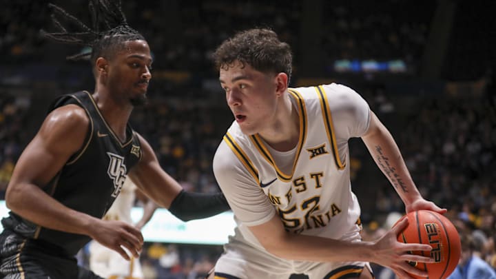 Mar 6, 2026; Morgantown, West Virginia, USA; West Virginia Mountaineers guard Treysen Eaglestaff (52) looks to make a move around UCF Knights guard Themus Fulks (1) during the second half at Hope Coliseum. Mandatory Credit: Ben Queen-Imagn Images