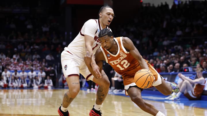 Mar 17, 2026; Dayton, OH, USA; Texas Longhorns guard Tramon Mark (12) drives to the basket defended by NC State Wolfpack forward Darrion Williams (1) in the second half during a first four game of the men's 2026 NCAA Tournament at University of Dayton Arena. Mandatory Credit: Rick Osentoski-Imagn Images