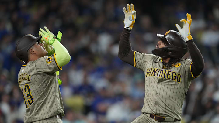 Sep 25, 2024; Los Angeles, California, USA;  San Diego Padres right fielder Fernando Tatis Jr. (23) celebrates with third baseman Manny Machado (13) after hitting a home run in the fifth inning against the Los Angeles Dodgers at Dodger Stadium. Mandatory Credit: Kirby Lee-Imagn Images