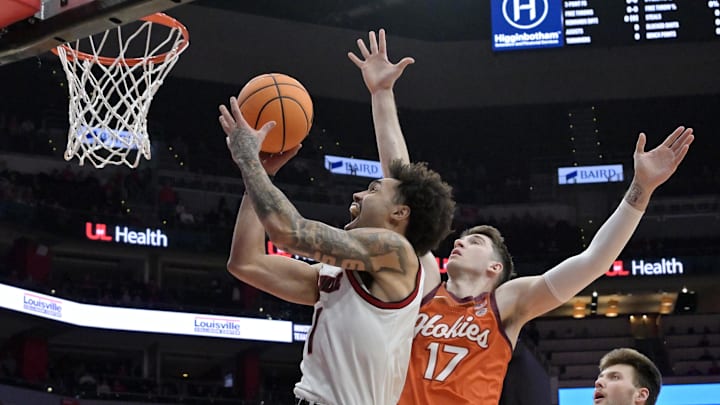 Jan 24, 2026; Louisville, Kentucky, USA;  Louisville Cardinals guard J'vonne Hadley (1) shoots against Virginia Tech Hokies guard Neoklis Avdalas (17) during the first half at KFC Yum! Center. Mandatory Credit: Jamie Rhodes-Imagn Images