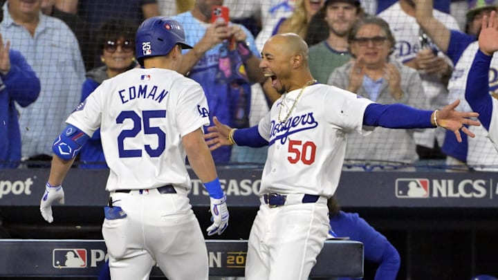 Oct 20, 2024; Los Angeles, California, USA; Los Angeles Dodgers shortstop Tommy Edman (25) celebrates with outfielder Mookie Betts (50) after hitting a two run home run in the third inning against the New York Mets during game six of the NLCS for the 2024 MLB playoffs at Dodger Stadium. Mandatory Credit: Jayne Kamin-Oncea-Imagn Images