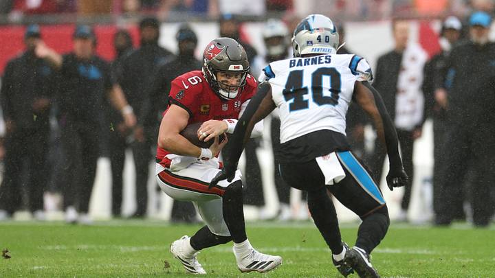 Jan 3, 2026; Tampa, Florida, USA; Tampa Bay Buccaneers quarterback Baker Mayfield (6) runs against Carolina Panthers linebacker Krys Barnes (40) in the first half at Raymond James Stadium. Mandatory Credit: Nathan Ray Seebeck-Imagn Images
