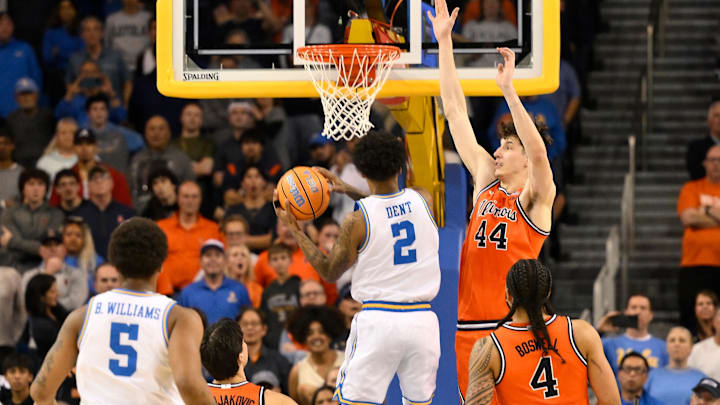 Feb 21, 2026; Los Angeles, California, USA; UCLA guard Donovan Dent (2) hangs in the air and scores the winning basket over Illinois center Zvonimir Ivisic (44) in overtime at Pauley Pavilion presented by Wescom Financial. Mandatory Credit: Robert Hanashiro-Imagn Images Feb 21, 2026; Los Angeles, California, USA; UCLA guard Donovan Dent (2) hangs in the air and scores the winning basket over Illinois center Zvonimir Ivisic (44) in overtime at Pauley Pavilion presented by Wescom Financial. Mandatory Credit: Robert Hanashiro-Imagn Images