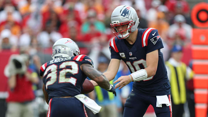 Nov 9, 2025; Tampa, Florida, USA; New England Patriots quarterback Drake Maye (10) hands the ball off to running back Treveyon Henderson (32) during the fourth quarter against the Tampa Bay Buccaneers at Raymond James Stadium. Mandatory Credit: Nathan Ray Seebeck-Imagn Images
