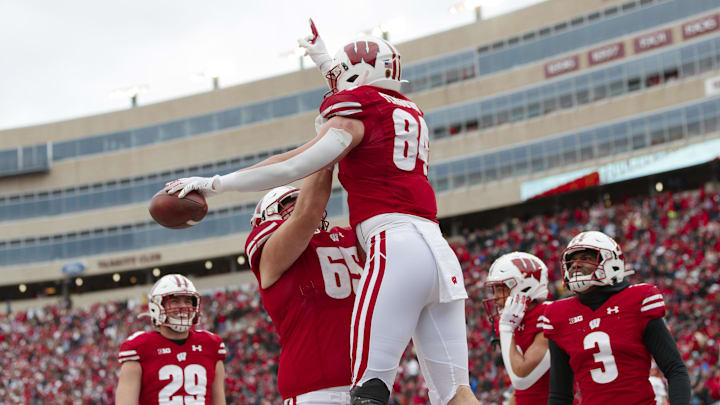 Nov 13, 2021; Madison, Wisconsin, USA;  Wisconsin Badgers tight end Jake Ferguson (84) celebrates with offensive lineman Tyler Beach (65) after scoring a touchdown during the third quarter against the Northwestern Wildcats at Camp Randall Stadium. Mandatory Credit: Jeff Hanisch-Imagn Images
