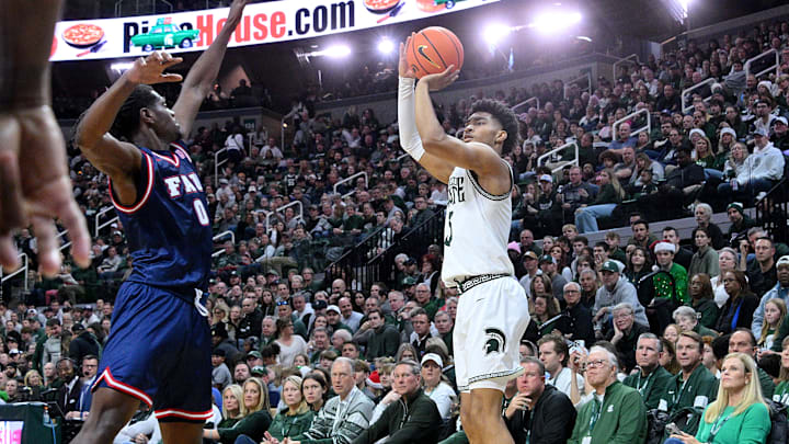 Dec 21, 2024; East Lansing, Michigan, USA; Michigan State Spartans guard Jaden Akins (3) shoots a three over Florida Atlantic Owls guard Ken Evans Jr. (0) during the second half at Jack Breslin Student Events Center. Mandatory Credit: Dale Young-Imagn Images Dec 21, 2024; East Lansing, Michigan, USA; Michigan State Spartans guard Jaden Akins (3) shoots a three over Florida Atlantic Owls guard Ken Evans Jr. (0) during the second half at Jack Breslin Student Events Center. Mandatory Credit: Dale Young-Imagn Images