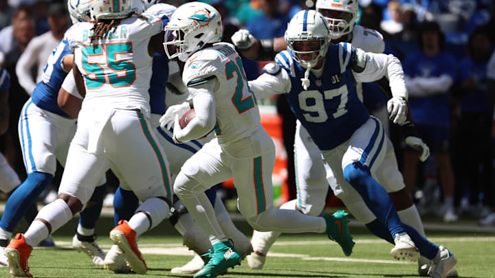 Sep 7, 2025; Indianapolis, Indiana, USA; Miami Dolphins running back De'Von Achane (28) runs against Indianapolis Colts defensive end Laiatu Latu (97) during the first half at Lucas Oil Stadium. Mandatory Credit: Trevor Ruszkowski-Imagn Images
