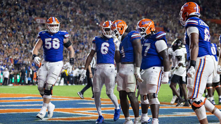 Oct 5, 2024; Gainesville, Florida, USA; Florida Gators running back Montrell Johnson Jr. (1) celebrates with Florida Gators offensive lineman Austin Barber (58), Florida Gators wide receiver Elijhah Badger (6), Florida Gators offensive lineman Knijeah Harris (77), and Florida Gators offensive lineman Brandon Crenshaw-Dickson (65) after scoring a touchdown against the UCF Knights during the first half at Ben Hill Griffin Stadium. Mandatory Credit: Matt Pendleton-Imagn Images