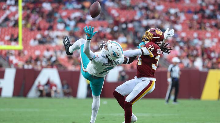 Miami Dolphins wide receiver Caleb Douglas (7) reaches for a pass as Washington Commanders cornerback Antonio Hamilton Sr. (34) defends during the first half at Northwest Stadium in the 2026 preseason opener.