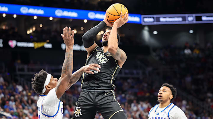 Mar 12, 2025; Kansas City, MO, USA; UCF Knights guard Darius Johnson (3) shoots the ball over Kansas Jayhawks forward Dillon Wilhite (22) during the second half at T-Mobile Center. Mandatory Credit: William Purnell-Imagn Images