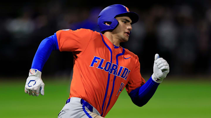 Florida utility Jac Caglianone (14) rounds first base en route to second after hitting a double