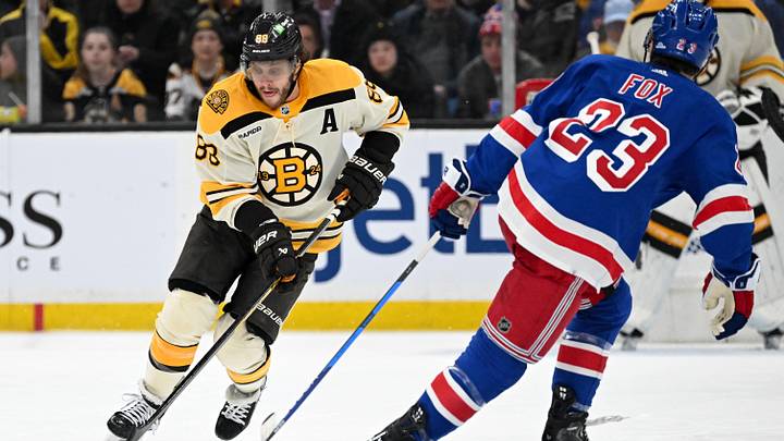 Mar 21, 2024; Boston, Massachusetts, USA; Boston Bruins right wing David Pastrnak (88) skates with the puck against New York Rangers defenseman Adam Fox (23) during the third period at the TD Garden. Mandatory Credit: Brian Fluharty-Imagn Images