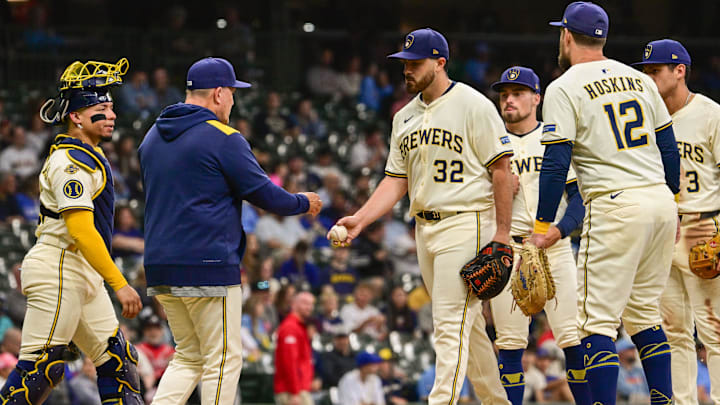 Jun 9, 2025; Milwaukee, Wisconsin, USA; Milwaukee Brewers starting pitcher Aaron Civale (32) hands the ball to manager Pat Murphy during a pitching change in the fifth inning against the Atlanta Braves at American Family Field. Mandatory Credit: Benny Sieu-Imagn Images