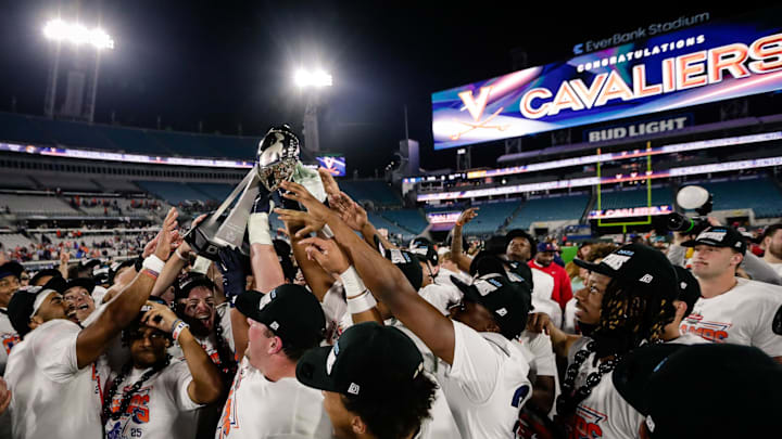 Dec 27, 2025; Jacksonville, FL, USA; Virginia Cavaliers players celebrate with the trophy after defeating the Missouri Tigers at EverBank Stadium. Mandatory Credit: Travis Register-Imagn Images