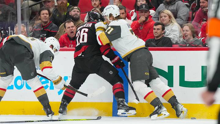 Oct 28, 2025; Raleigh, North Carolina, USA; Vegas Golden Knights center William Karlsson (71) checks Carolina Hurricanes defenseman Sean Walker (26) during the third periodat Lenovo Center. Mandatory Credit: James Guillory-Imagn Images