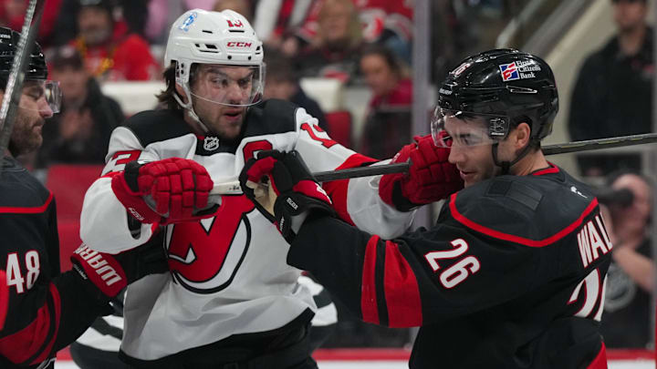 Carolina Hurricanes defenseman Sean Walker (26) and New Jersey Devils center Nico Hischier (13) battle: James Guillory-Imagn Images