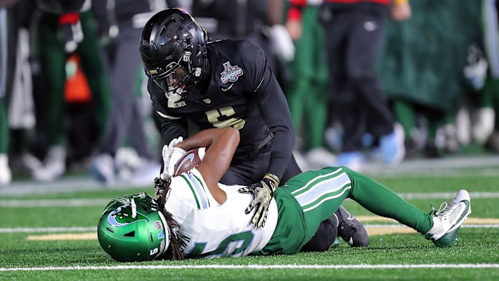 Dec 6, 2024; West Point, NY, USA; Army Black Knights cornerback Justin Weaver (5) tackles Tulane Green Wave wide receiver Yulkeith Brown (5) during the second half at Michie Stadium. Dec 6, 2024; West Point, NY, USA; Army Black Knights cornerback Justin Weaver (5) tackles Tulane Green Wave wide receiver Yulkeith Brown (5) during the second half at Michie Stadium.