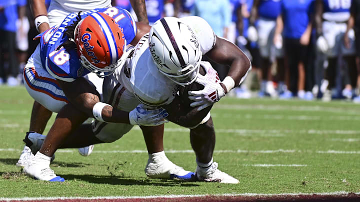 Mississippi State Bulldogs running back Johnnie Daniels (20) runs the ball against Florida Gators defensive back Bryce Thornton (18) during the fourth quarter at Davis Wade Stadium at Scott Field.