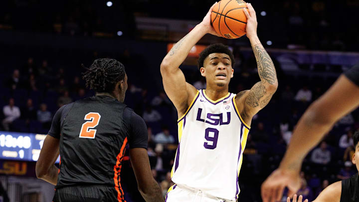 Nov 29, 2024; Baton Rouge, Louisiana, USA;  LSU Tigers forward Jalen Reed (9) looks to pass the ball against Northwestern State Demons forward Jerald Colonel (2) during the first half at Pete Maravich Assembly Center. Mandatory Credit: Stephen Lew-Imagn Images