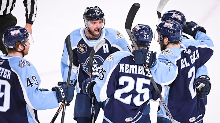 Teammates including Cal O'Reilly (16) surround Milwaukee Admirals right wing Joakim Kemell (25) to celebrate his goal against the Coachella Valley Firebirds in the first period of Game 4 of their AHL playoff series Thursday, June 6, 2024, at the UW-Milwaukee Panther Arena in Milwaukee, Wisconsin.